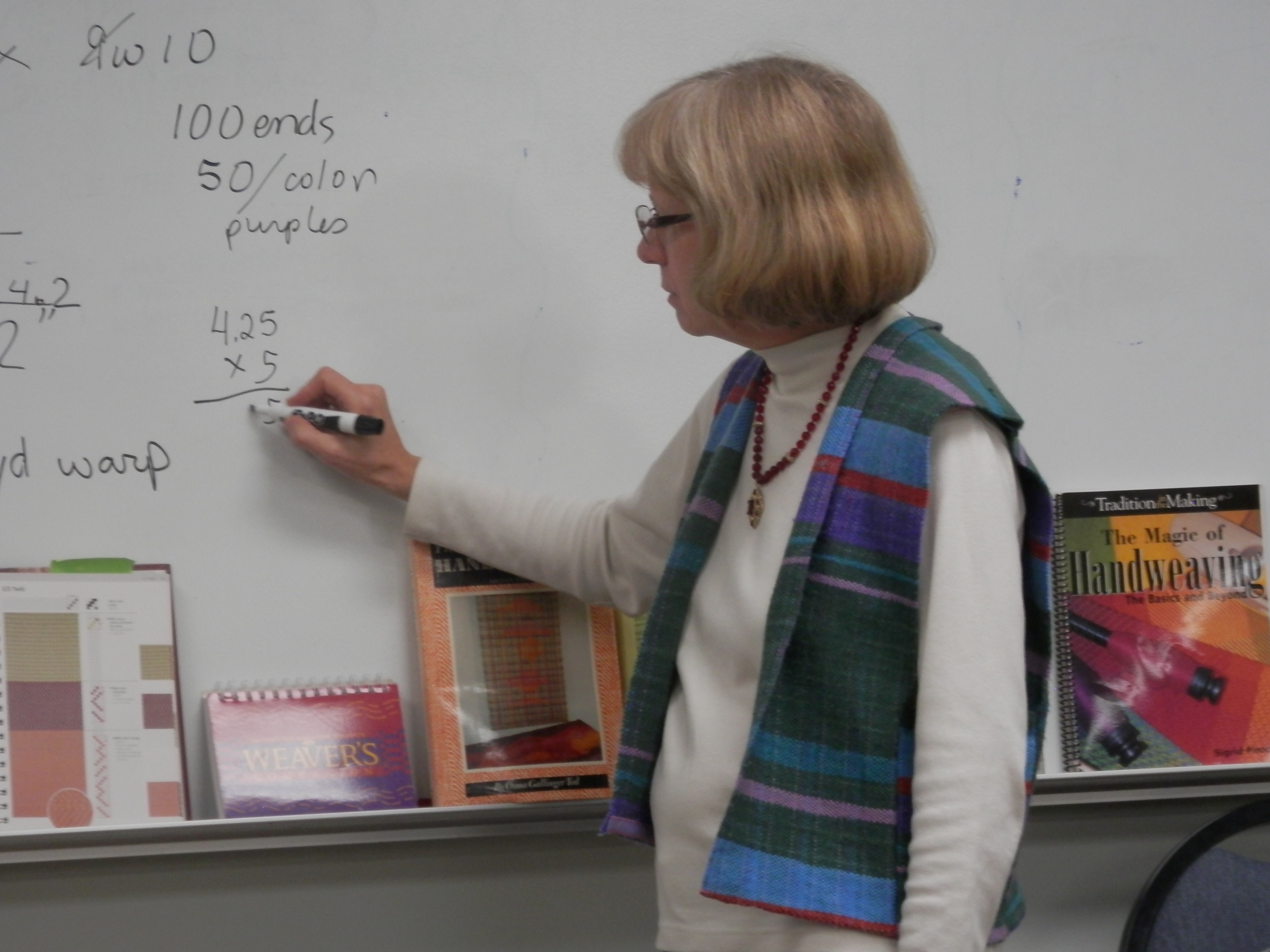 Linda, wearing the striped vest, led the group through the math calculations.