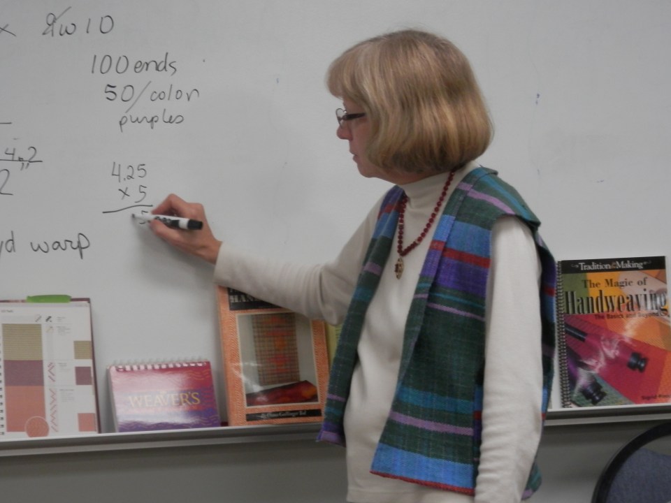 Linda, wearing the striped vest, led the group through the math calculations.